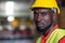 Portrait of African America engineer wearing safety helmet and vest standing in the automotive warehouse with blur background and