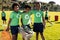 Portrait of african american boys collecting recycling embracing in sunny elementary school field