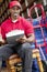 Portrait of a African American delivery man sitting on chair with clipboard