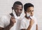 Portrait Of African American Father And Son Shaving In Bathroom Together