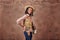 Portrait of an african american girl cowboy with hat and pistol in holster. photo in the studio. brown background