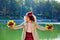 Portrait of an African-American girl in a park with a bouquet of autumn leaves on the background of a lake. Playing with maple