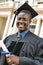 Portrait of African American Graduate with Diploma in Front of University Building