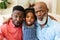 Portrait of african american grandfather, father and granddaughter making silly faces at home