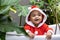 Portrait of African American little toddler baby girl in santa christmas dress smiling and playing inside the bathtub surrounding