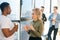 Portrait of African American male having conversation with young woman colleague, selective focus.