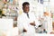 Portrait of african american male pharmacist in pharmacy demonstrating goods