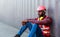 Portrait of an African American male technician or engineer. Sit near a shipping container and look tired and sleepy or unemployed