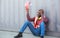 Portrait of an African American male technician or engineer. Sit near a shipping container and look tired and sleepy or unemployed