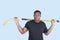 Portrait of an African American man holding hockey stick over blue background