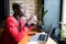 Portrait of an African American man in a jacket drink coffee and work on a laptop