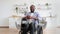 Portrait of african american wheelchair user resting in kitchen