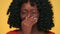 Portrait of african american woman with dark curly hair feeling bad smell and covering nose with hand. Disgusting odour