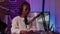 Portrait of african american woman podcaster sitting at desk reading content from laptop screen