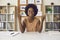 Portrait african american woman sitting at office desk with raised palms