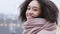 Portrait of african american young girl dark-skinned lady with curly afro hairstyle wears pink warm scarf in winter cold