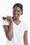 Portrait of an African American young woman with dumbbell over white background