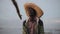 Portrait of African fisherman in straw hat. Young man sitting in boat and catches fish alone.