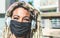 Portrait of african girl with blond dreadlocks hair listening music while wearing face protective mask for Coronavirus prevention