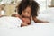 Portrait of African newborn baby sleeping on a white bed. His little sister kissing infant boy with love. New siblings relationshi