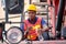 Portrait of African worker eat bread and hold bottle of water stay on big crane tractor