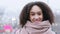 Portrait of afro american authentic girl teenager dark-skinned girl with curly hair wears warm winter clothes pink scarf