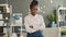 Portrait of Afro-American girl office worker smiling with arms crossed in workplace