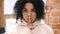 Portrait of Afro-American woman gesturing  silence, finger on lips, indoor