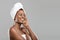 Portrait of afro woman with towel on head and perfect skin