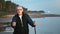 Portrait aged 70s grandfather posing walking stick at sunset beach sea shore sail boat