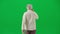 Portrait of aged bearded man on chroma key green screen. Senior man in casual clothing walking, back view.