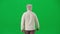 Portrait of aged bearded man on chroma key green screen. Senior man in casual clothing walking, back view.