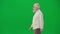 Portrait of aged bearded man on chroma key green screen. Senior man walking and looking away from camera, profile view.