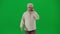 Portrait of aged bearded man on chroma key green screen. Senior man walking and looking at the camera, talks on