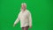 Portrait of aged bearded man on chroma key green screen. Senior man walking and looking sideway from camera. Half turn.