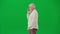 Portrait of aged bearded man on chroma key green screen. Senior man walking and talks on smartphone, profile view.