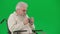 Portrait of aged disabled man on chroma key green screen. Close up senior man sitting in wheelchair feeling cold