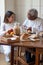 Portrait of aged father and daughter talking in cosy kitchen