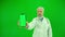 Portrait of aged man medic on chroma key green screen. Close up of senior doctor in uniform holding smartphone and