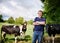 Portrait, agriculture and cows with a man on a dairy farm outdoor in summer for natural sustainability. Confident, milk