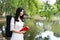 Portrait Aisan Chinese girl woman artist carry violin bag and carry a book by lake forest enjoy free causal life sunshine day