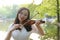 Portrait Aisan Chinese girl woman artist play violin in nature park forest enjoy leisure time performance outdoor lake sunrise