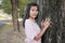 Portrait alone woman standing with big tree nature in park.