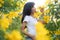 Portrait Alone Woman with white t-shirt standing in Yellow elder or Trumpetbush Flowers Park. free space for add text presentation