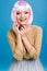 Portrait amazing young woman with pink haircut on blue background. Brightful makeup with pink tinsels, tulle skirt