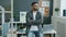 Portrait of ambitious mixed race guy standing in office and looking at window