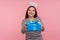 Portrait of angelic girl with saint halo over head giving birthday gift and smiling, sharing present, donating