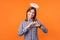 Portrait of angelic young woman with charming smile. indoor studio shot isolated on orange background