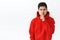 Portrait of angry, displeased asian hipster man in red hoodie, frowning furious, shushing at person scolding someone bad