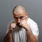 Portrait of a angry man holding fists against gray background